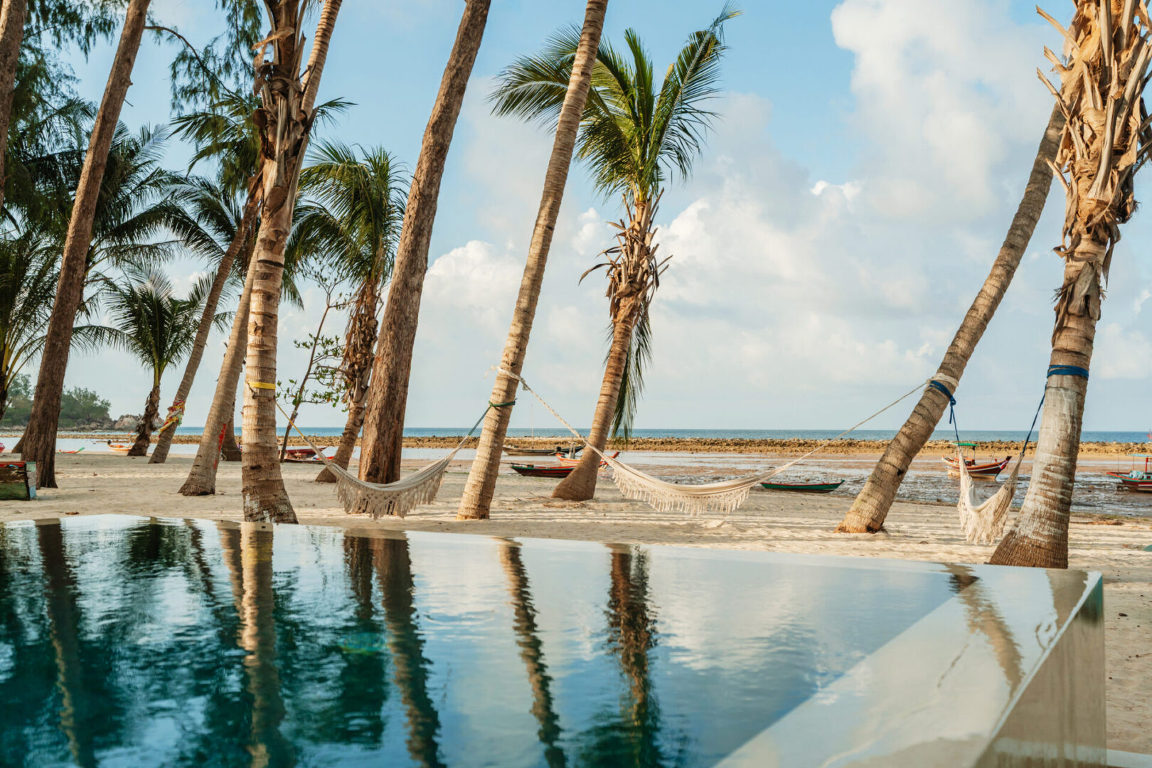 Hammocks between palm trees on sandy beach