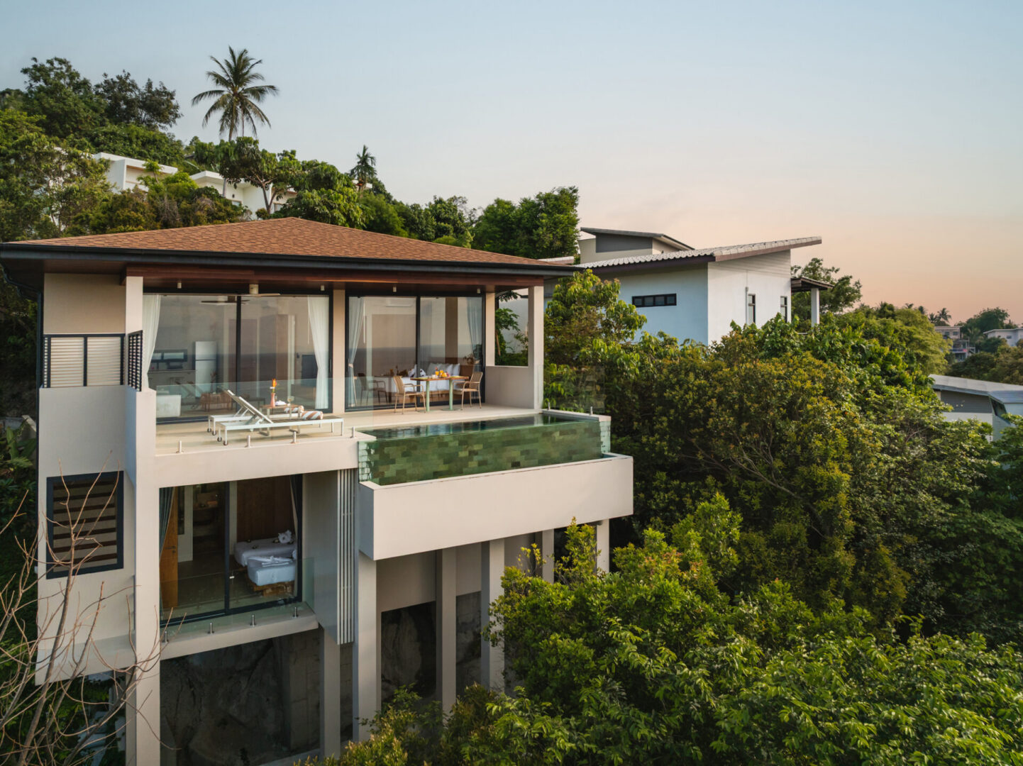 Modern hillside villa surrounded by lush greenery