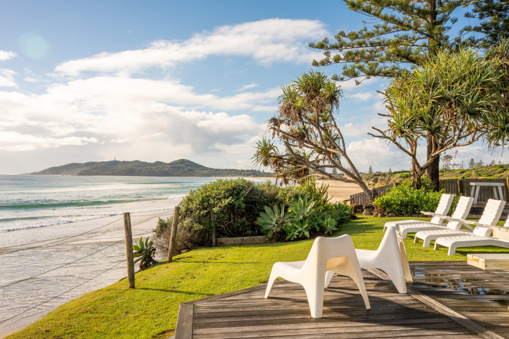 Beachfront lounge chairs under sunny sky