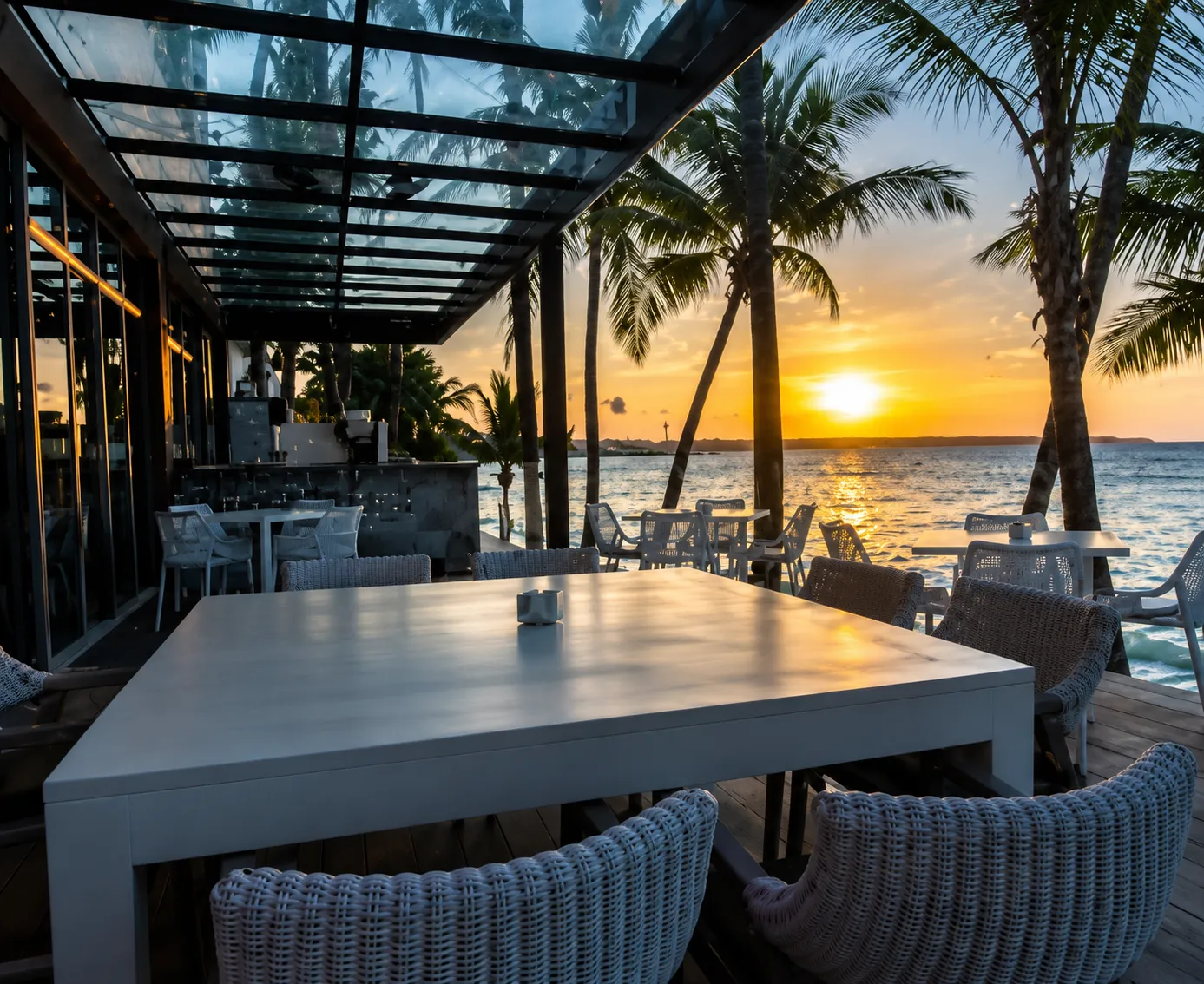Outdoor dining by the sea at sunset.