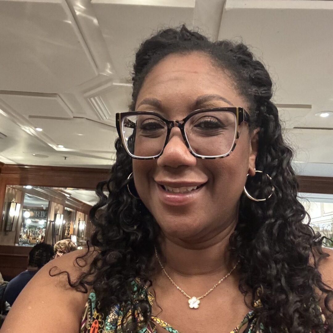 Smiling woman with glasses in a restaurant.